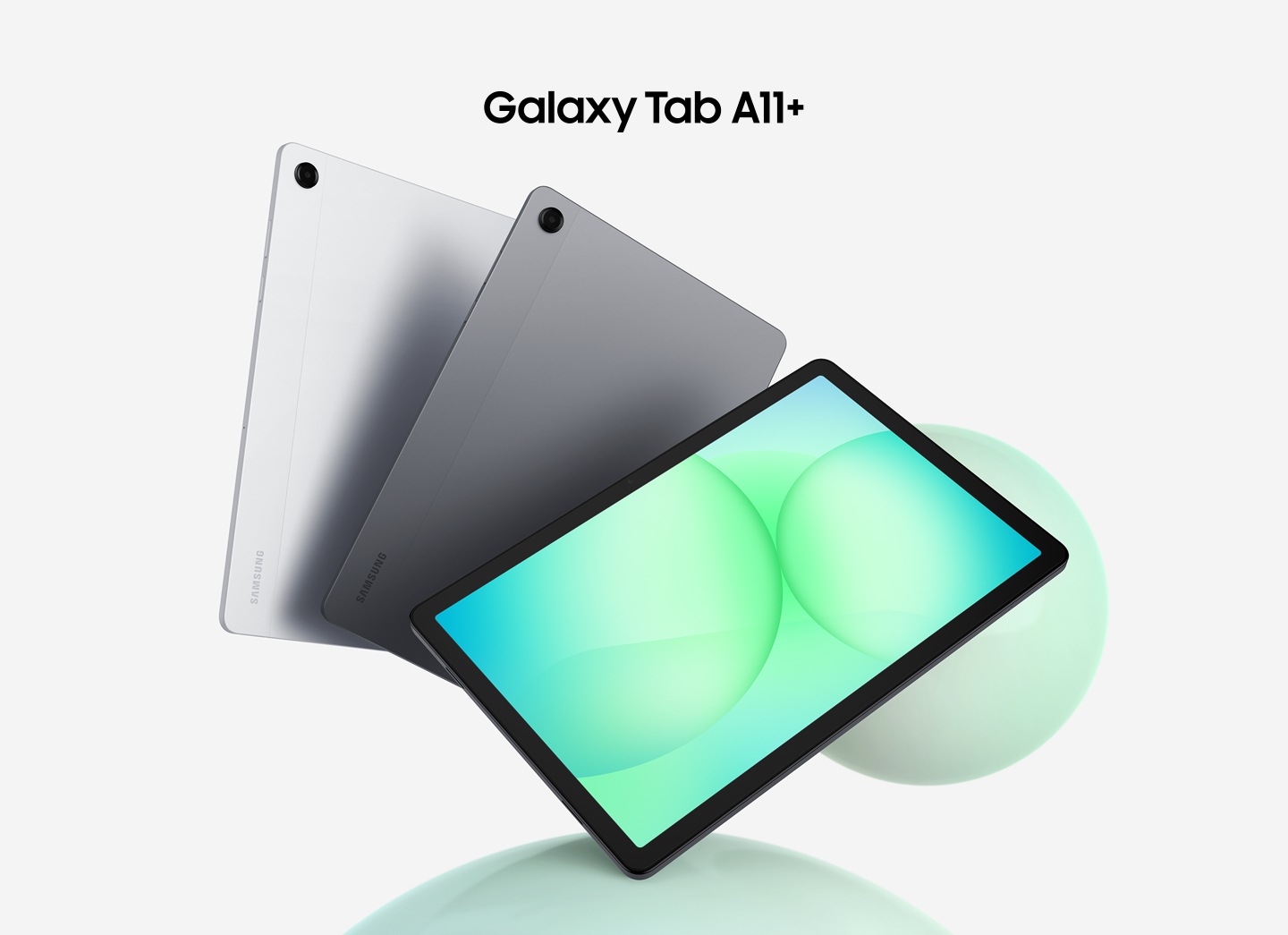 Tres tabletas Galaxy Tab A11+ están dispuestas en forma de abanico. Las dos primeras, a la izquierda, muestran su parte trasera en color plata y gris, mientras que la tableta frontal muestra un gráfico circular verdoso en su pantalla. Encima de las tabletas, se lee el texto «Galaxy Tab A11+».