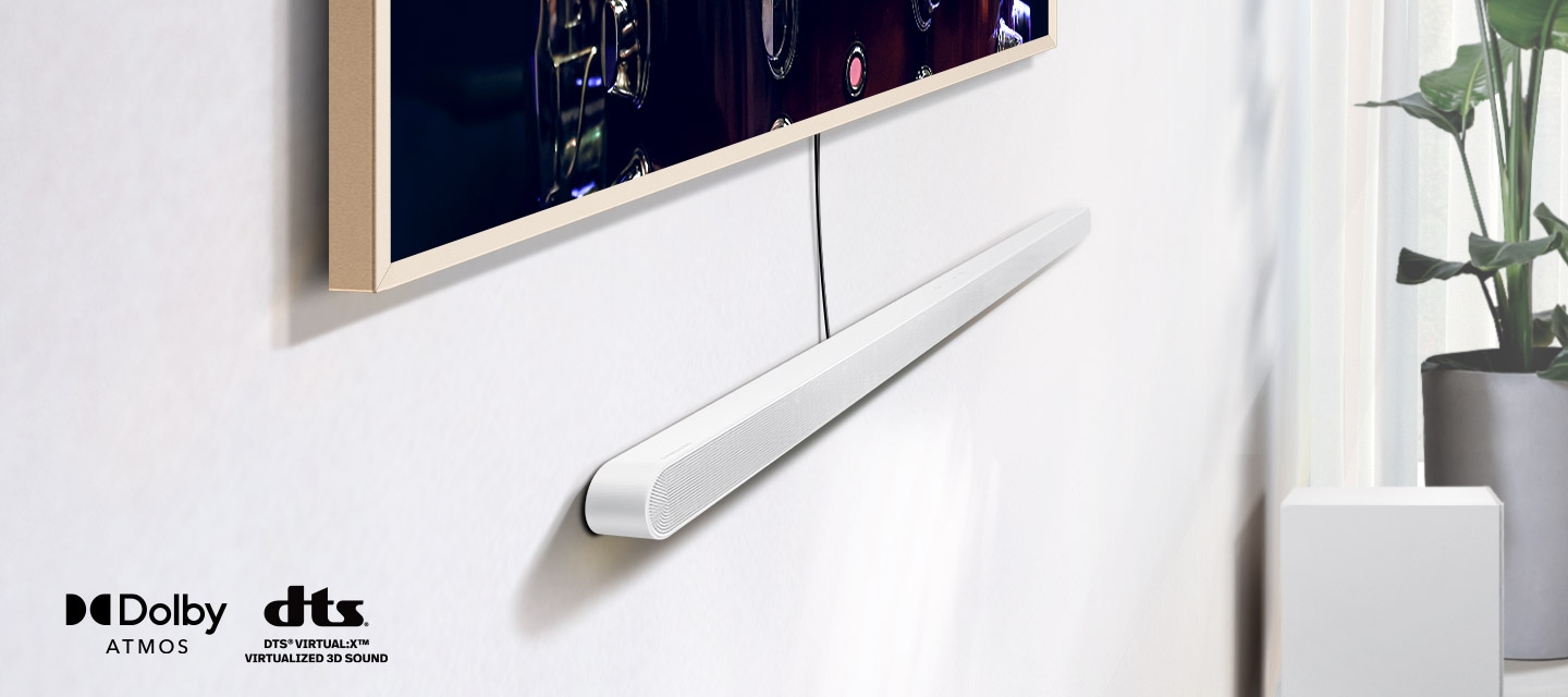 Detailní záběr na Ultra Slim Soundbar nainstalovaný pod televizorem spolu s logy pro Dolby Atmos a DTS Virtual:X. V blízkosti zařízení Soundbar se objeví ikona signálu Wi-Fi. Scéna se oddálí a odhalí celý obývací pokoj. Soundbar vydává řadu kulatých zvukových vln.