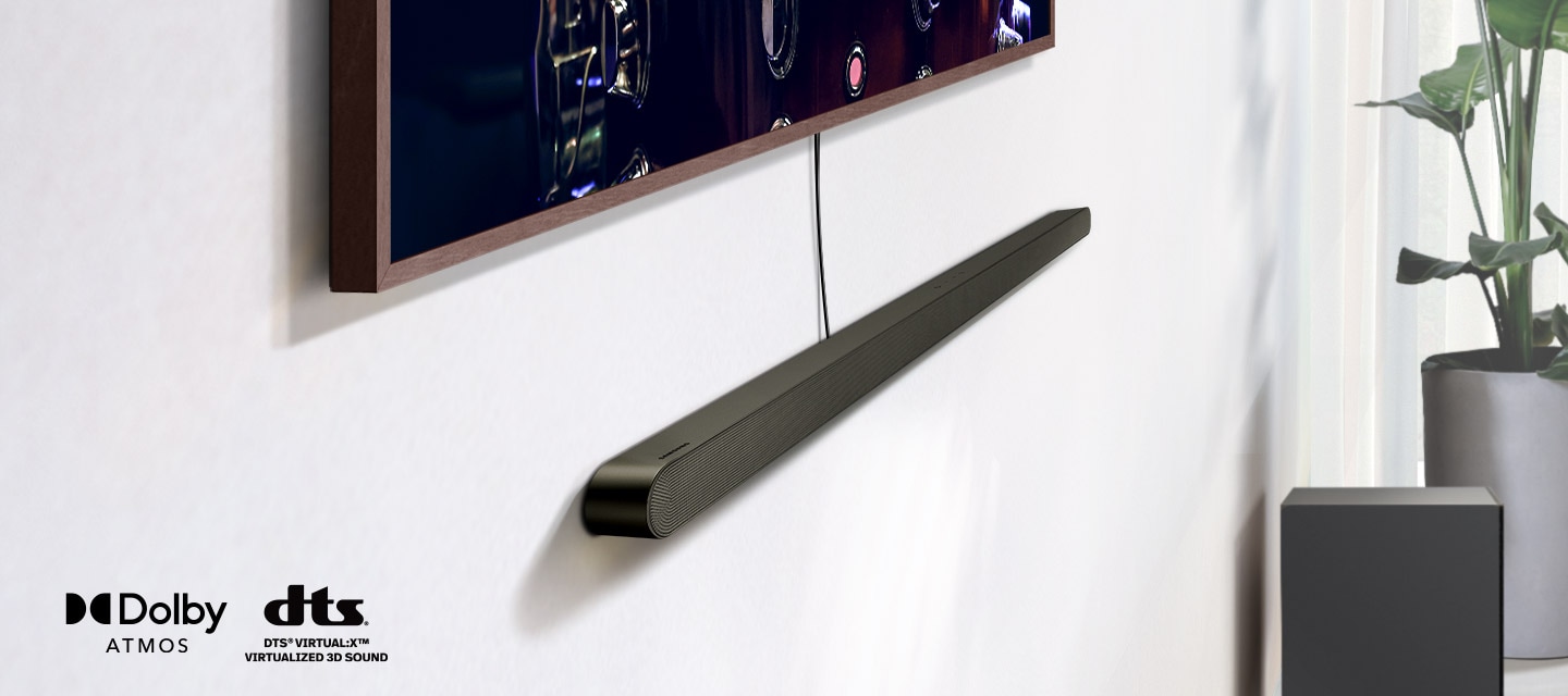 Detailní záběr na Ultra Slim Soundbar nainstalovaný pod televizorem spolu s logy pro Dolby Atmos a DTS Virtual:X. V blízkosti zařízení Soundbar se objeví ikona signálu Wi-Fi. Scéna se oddálí a odhalí celý obývací pokoj. Soundbar vydává řadu kulatých zvukových vln.