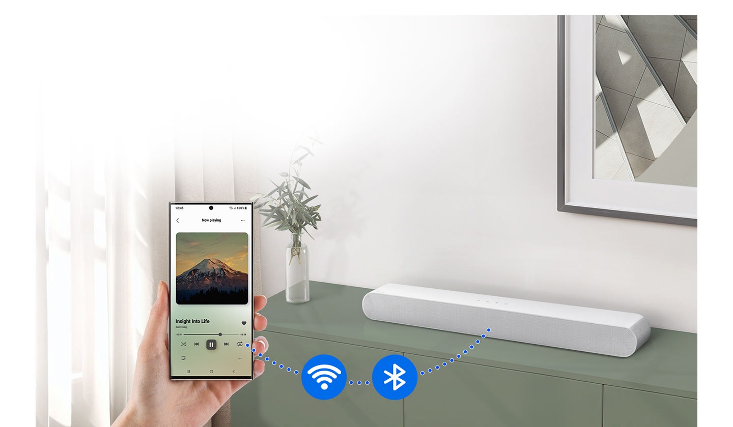 Smartphone je připojen k zařízení Soundbar pomocí tečkované čáry. Tečkovaná čára má ikony pro Wi-Fi a Bluetooth.