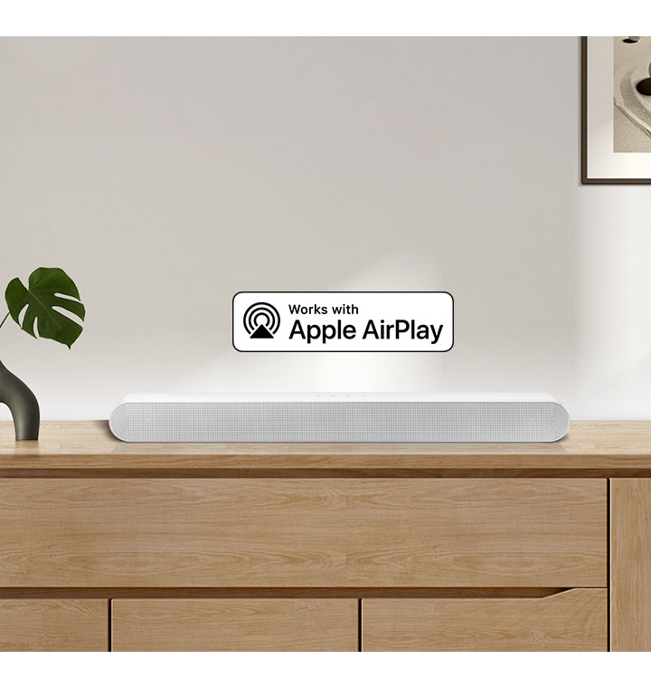 Soundbar Samsung je umístěn na horní straně skříně a je doplněn logem pro Works with Apple AirPlay.