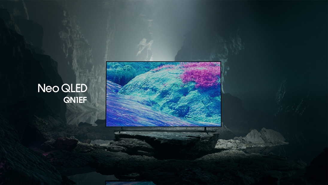 Televizor Samsung Neo QLED QN1EF v černobílém podzemním prostoru zobrazuje barevnou scénu z nadpozemské krajiny. 