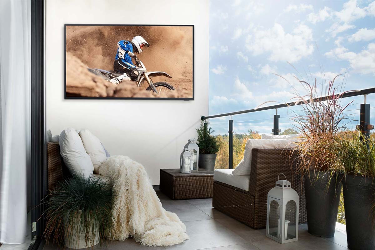 The Terrace tv on deck which unaffected by sunset is displaying a man motorcycling