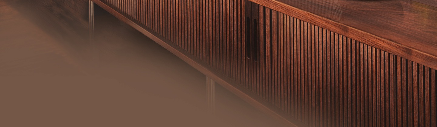 Samsung S series Soundbar and subwoofer are positioned with Samsung TV on living room cabinet.