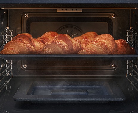 Shows a close-up of croissants being baked in the oven, but being kept moist with steam using the Natural Steam option.