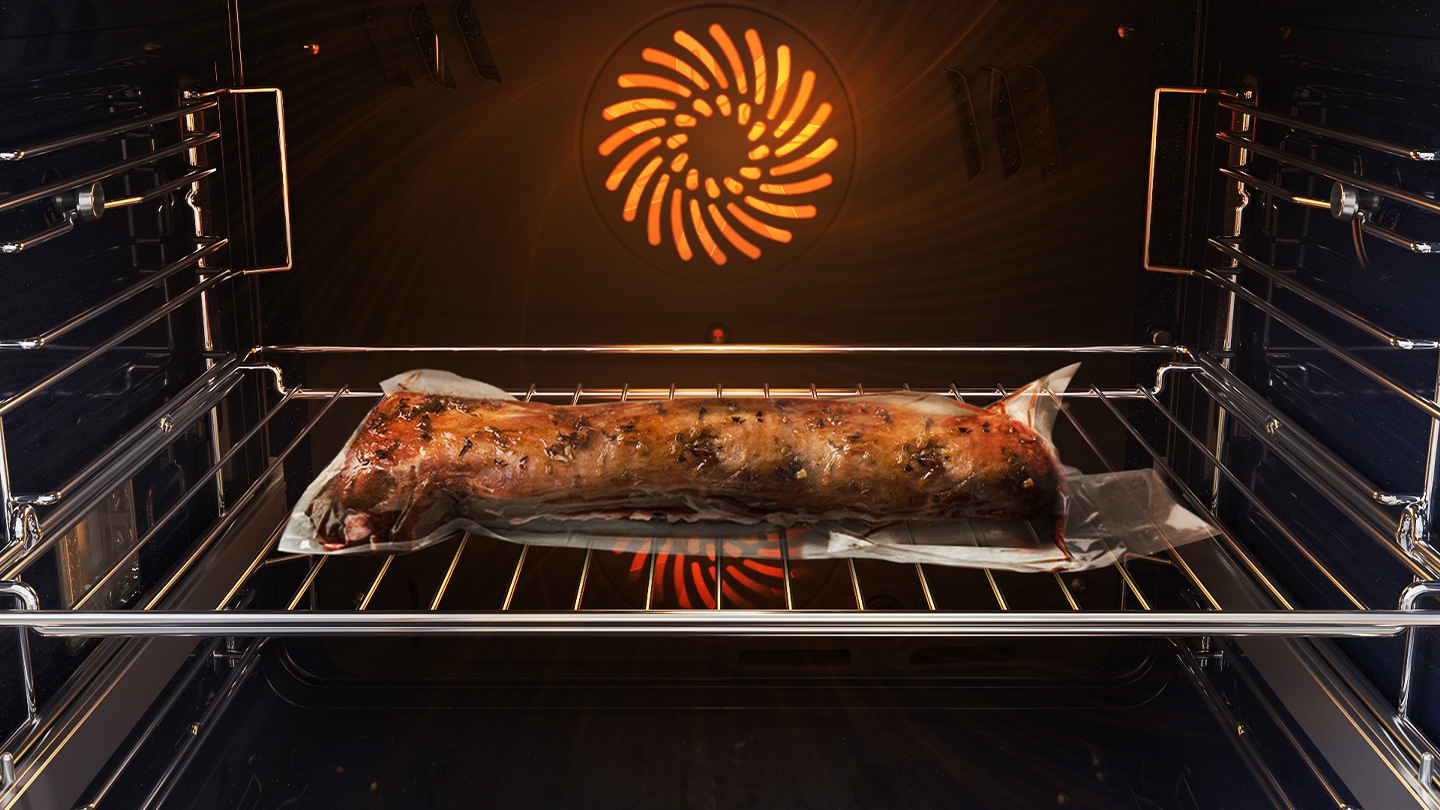 Mostra un arrosto di carne all'interno del forno, che è ben sigillato in un sacchetto di plastica e su una teglia di metallo, mentre viene cotto con il sistema Air Sous Vide.