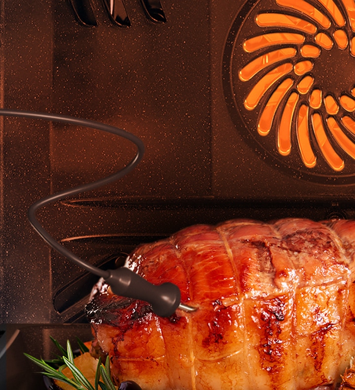 Afișează o sondă alimentară introdusă într-un rost de carne care este prăjită.