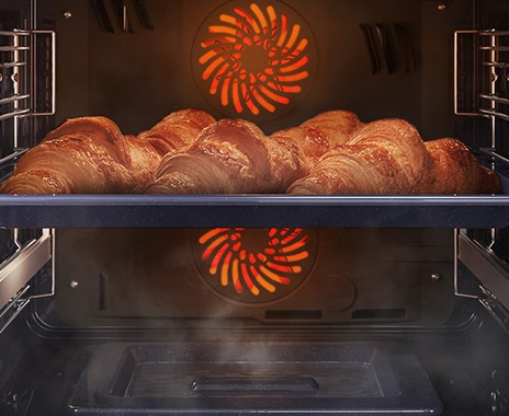 Shows a close-up of croissants being baked in the oven, but being kept moist with steam using the Natural Steam option.