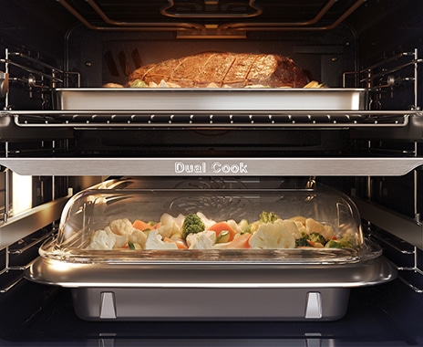 Shows the inside of the oven with a joint of meat roasting in the top zone and vegetables being steamed in the lower zone.