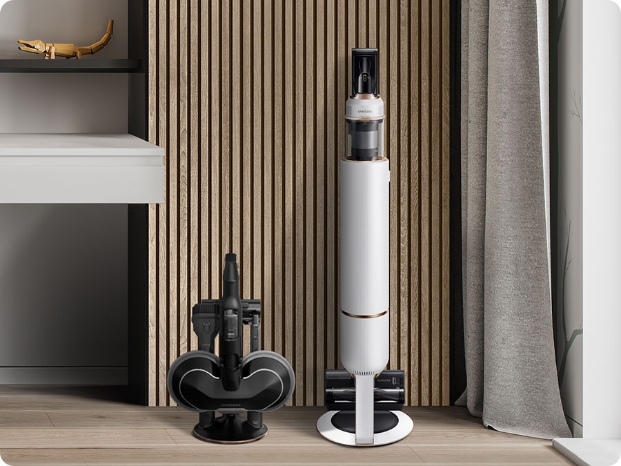 Suportul pentru accesorii al modelului Bespoke Jet Plus se află în fața unui perete modern din lemn, lângă o stație de curățenie.