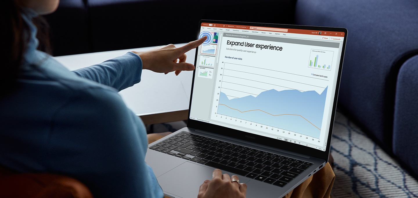 Das Galaxy Book4 Pro in Platinum Silver ist geöffnet, während eine Präsentation in der Microsoft PowerPoint-App auf dem Bildschirm läuft und eine Person mit dem Finger auf den Touchscreen tippt.