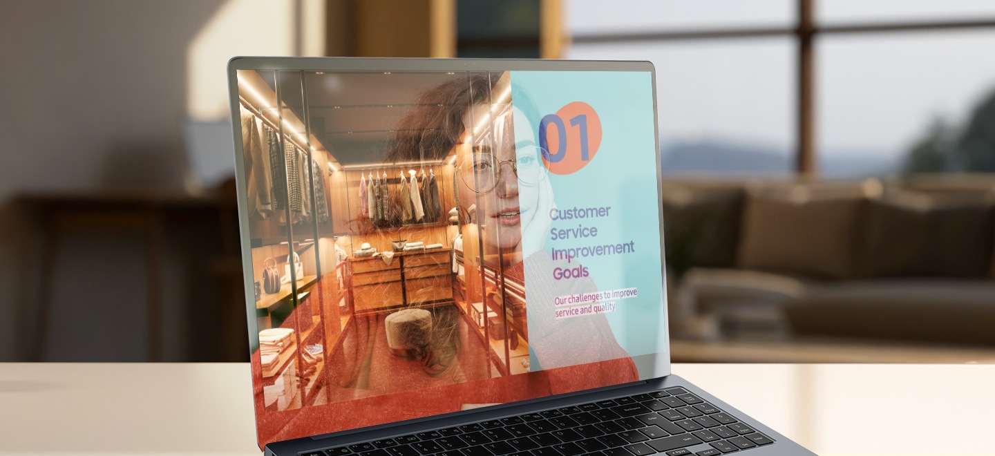 Das Galaxy Book4 Pro liegt aufgeklappt auf einem Schreibtisch und ist leicht nach rechts ausgerichtet, wobei ein Bild einer Hauseinrichtung im Vollbildmodus angezeigt wird. Das Bild auf dem Bildschirm weist einige Spiegelungen und Blendungen auf.