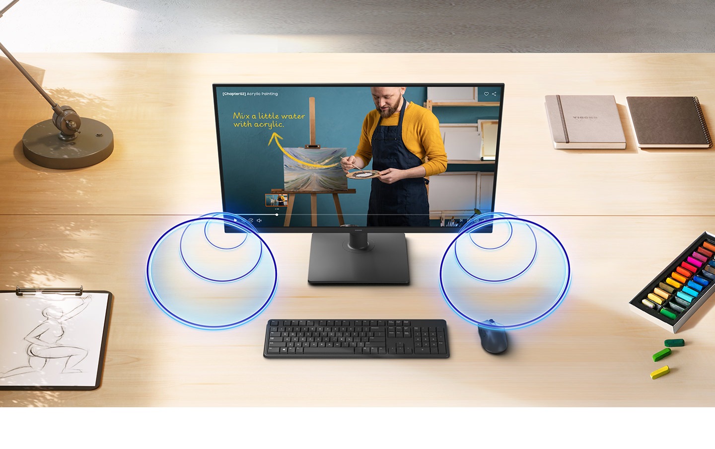 A video content is being played on the Essential Monitor S4r on the desk, and there are some round circles in front of the monitor, representing the speakers.