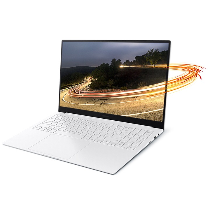 Light swirls encircle a laptop screen, encompassing a photo of a mountain road displayed on the screen of Galaxy Book Pro.