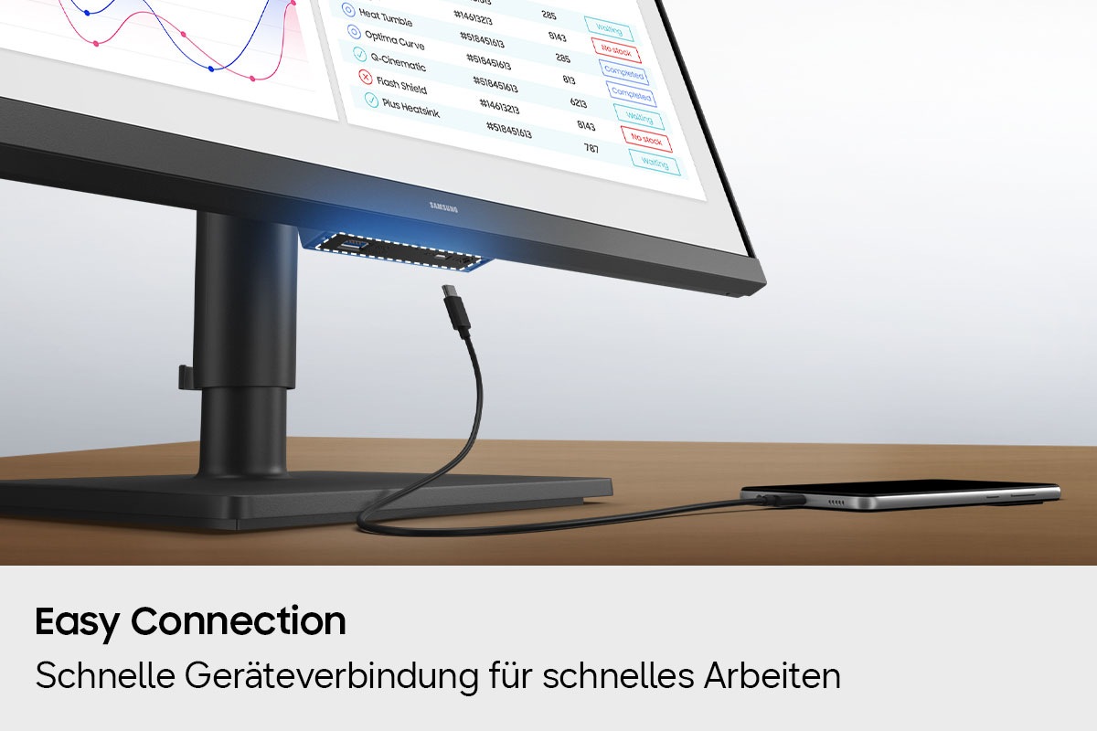 Ein Anschluss an der Unterseite des Monitors ist hervorgehoben, und ein Ladegerät für ein Smartphone wird dargestellt, das versucht, eine Verbindung herzustellen.