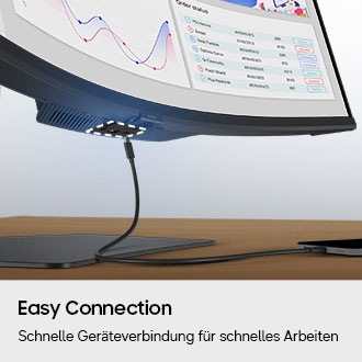 Ein Anschluss an der Unterseite des Monitors ist hervorgehoben, und ein Ladegerät für ein Smartphone wird dargestellt, das versucht, eine Verbindung herzustellen.