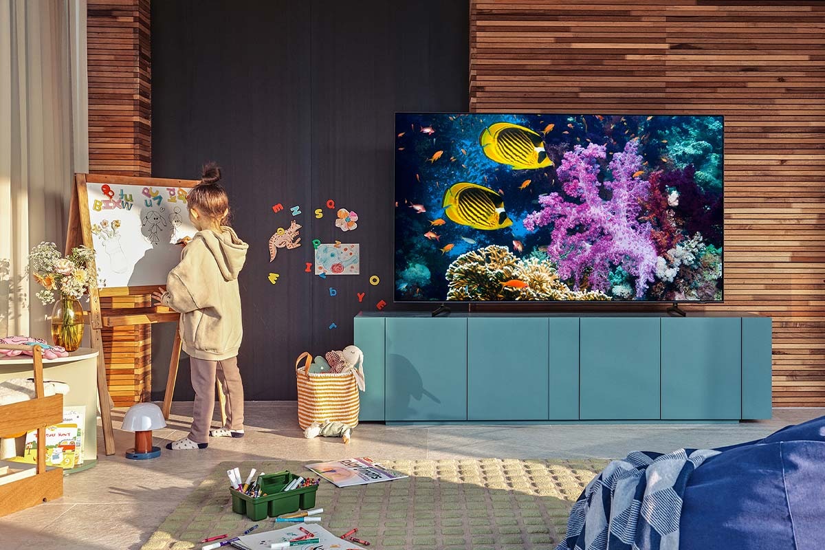 Et Samsung QLED Q60A med 4K Dual LED hænger i en stue og viser et billede på skærmen