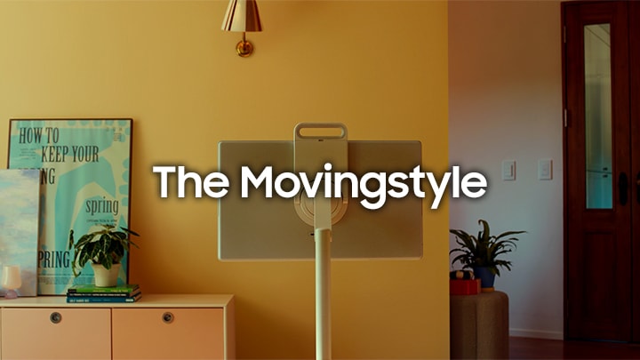 Samsung The Movingstyle står i midten af et gult rum. Teksten “The Movingstyle”, planter og en plakat ses i baggrunden.