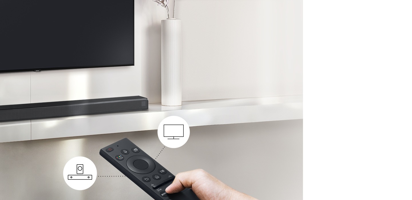 Un usuario controla las funciones de la barra de sonido y del televisor con el control remoto del televisor Samsung.