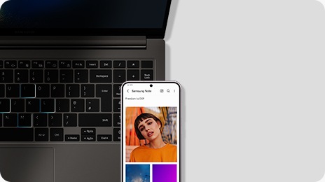 A top close-up view of a graphite Galaxy Book3, open and facing forward. A Galaxy S23 Plus device is placed in front of the laptop with an image opened in the Samsung Notes app.