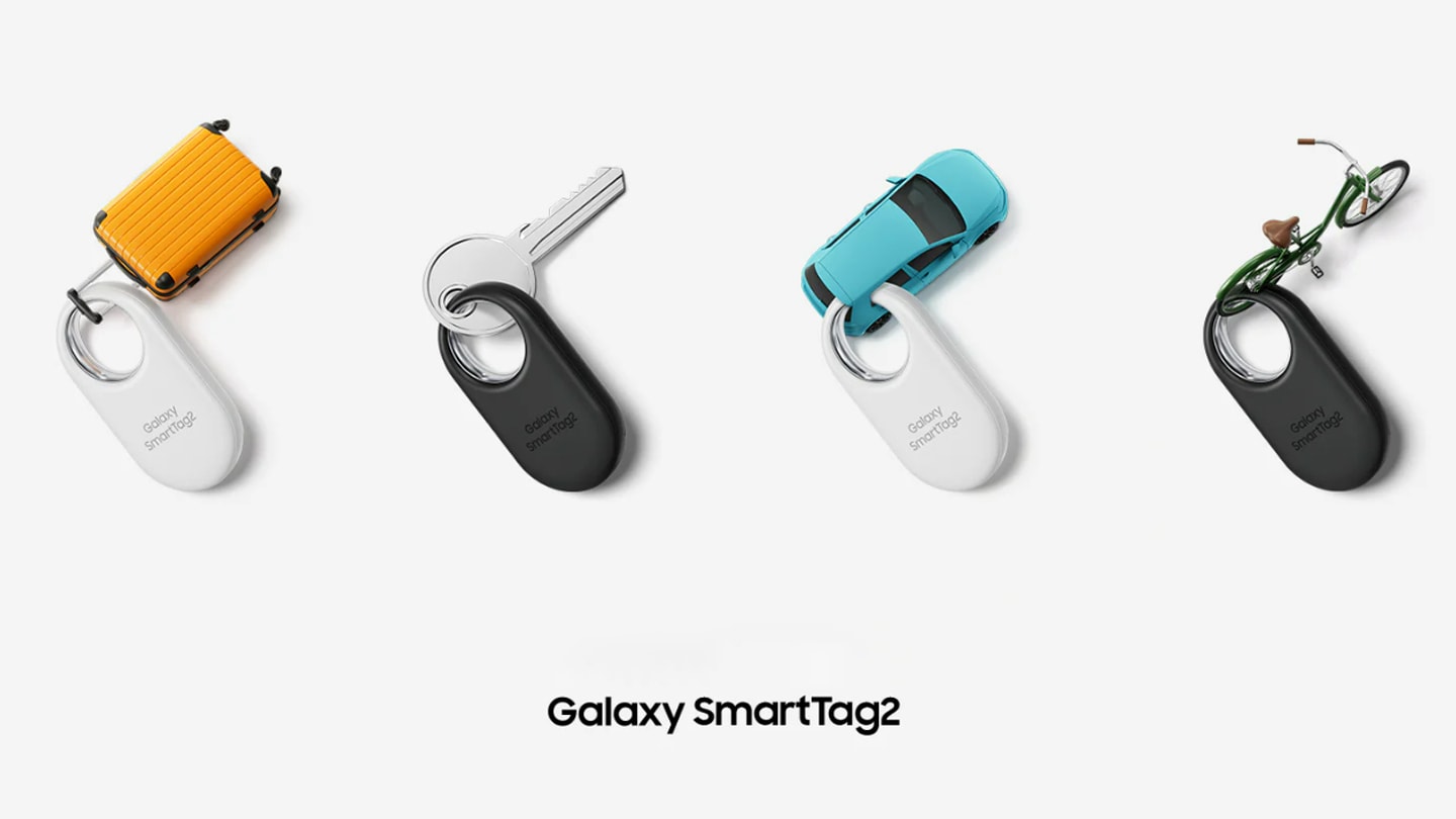 Four Galaxy SmartTag2 devices, two in white and two in black, are neatly placed. The devices are tagged to the following items: A miniature suitcase, a key, a miniature car, and a miniature bicycle.