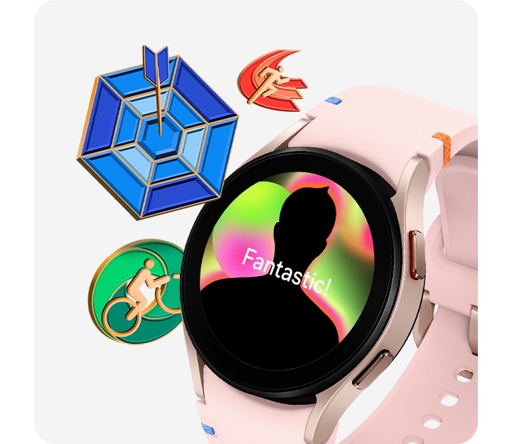 A pink gold Galaxy Watch FE with a pink stitch band is seen from the slanted left front. The watch face displays a reward badge congratulating the user's accomplishment. To the left of the watch, there are three other reward badges: a running badge, an arrow hitting a bulls-eye on a target, and a person on a bicycle.