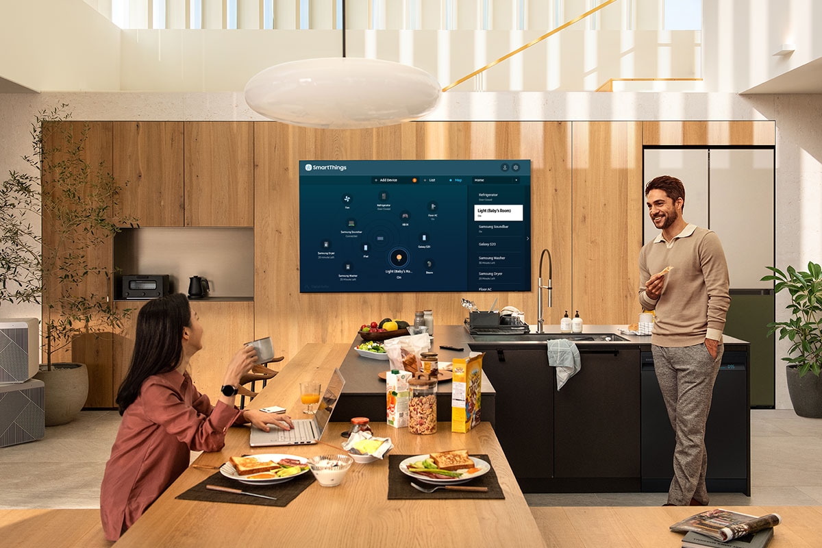 Televisor Qled Q70 ubicado en una cocina y que muestra en su pantalla la conexión que realiza con los dispositivos que tiene a su alrededor