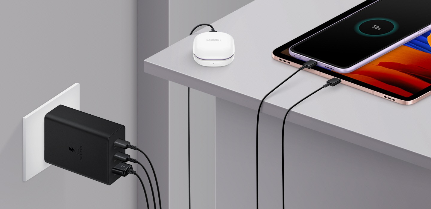 65 W Power Adapter Trio ühendatakse seinakontakti, et laadida samaaegselt nutitelefoni, tahvelarvutit ja Galaxy Buds2.