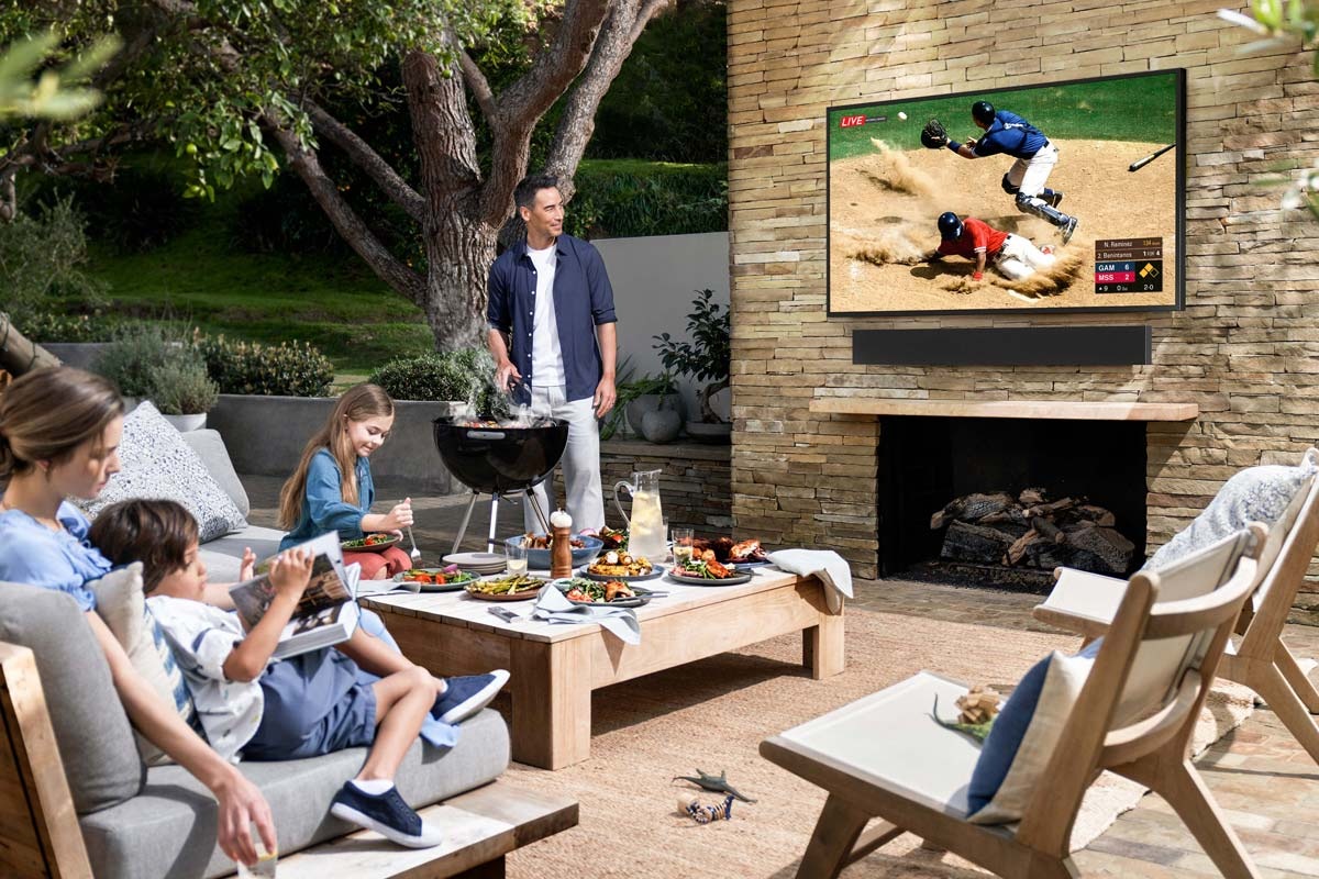 Perhe syö ateriaa ulkokäyttöön tarkoitetun The Terrace -television edessä