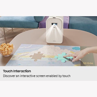 The Premiere heijastaa pulmapelin näytön pöydälle, ja käyttäjä liikuttaa palapelin palaa sormellaan.