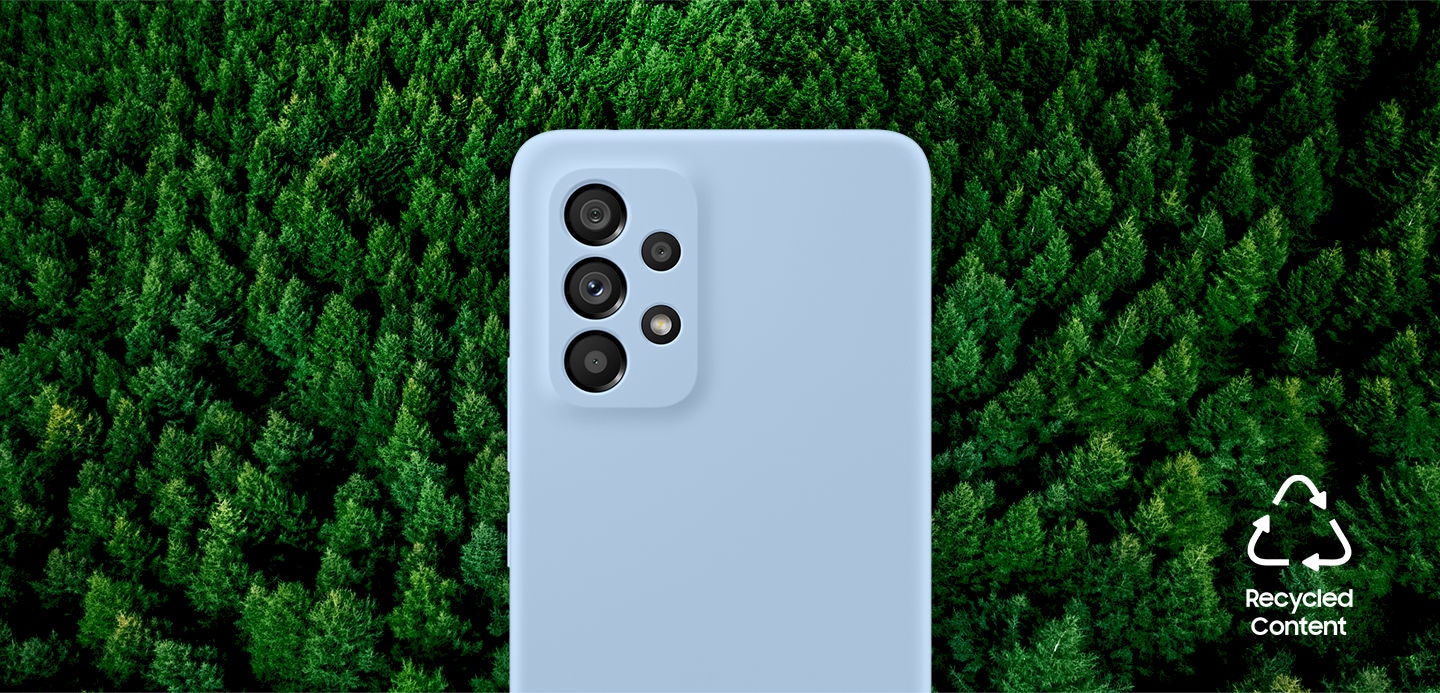 Galaxy A53 5G vu de l'arrière avec la couverture en silicone installée. L'arrière-plan est une forêt. Le texte indique "Contenu recyclé".