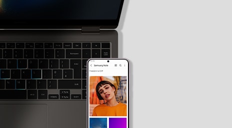 Fechar a visão de um Galaxy Book3 Pro 360 antracite, aberto e atirado em frente. Um Ultra Galaxy S23 é colocado em frente ao laptop com uma mulher na tela no aplicativo Samsung Notes