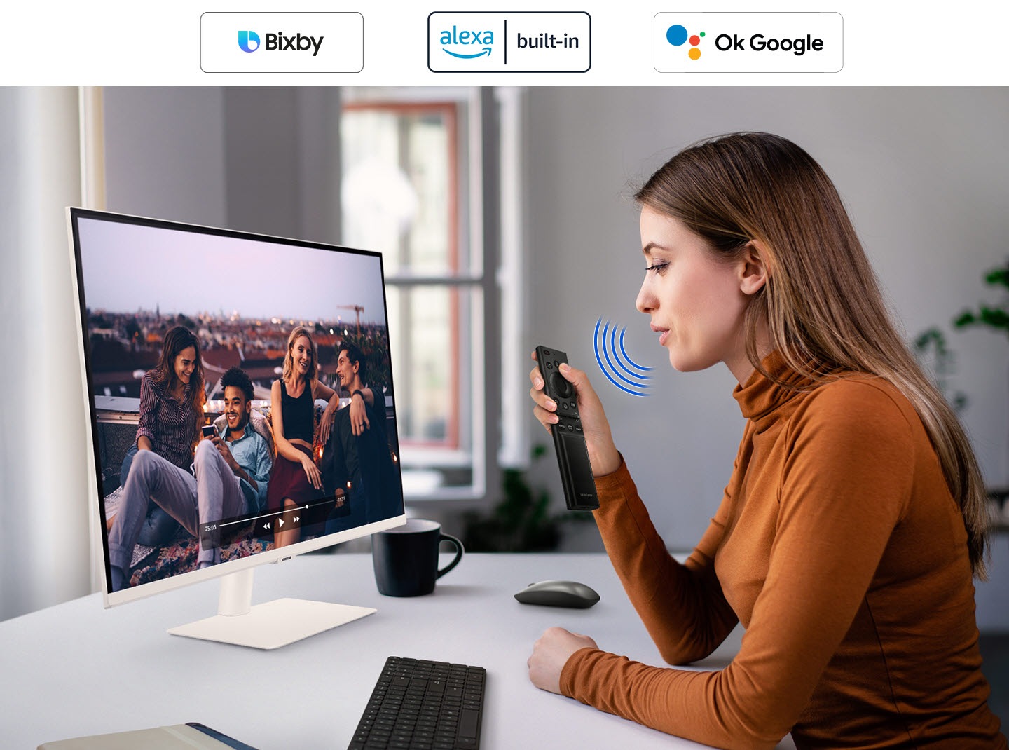 A woman speaks to the monitor. And a video is played on it. The Bixby and SmartThings icon is in the right corner.