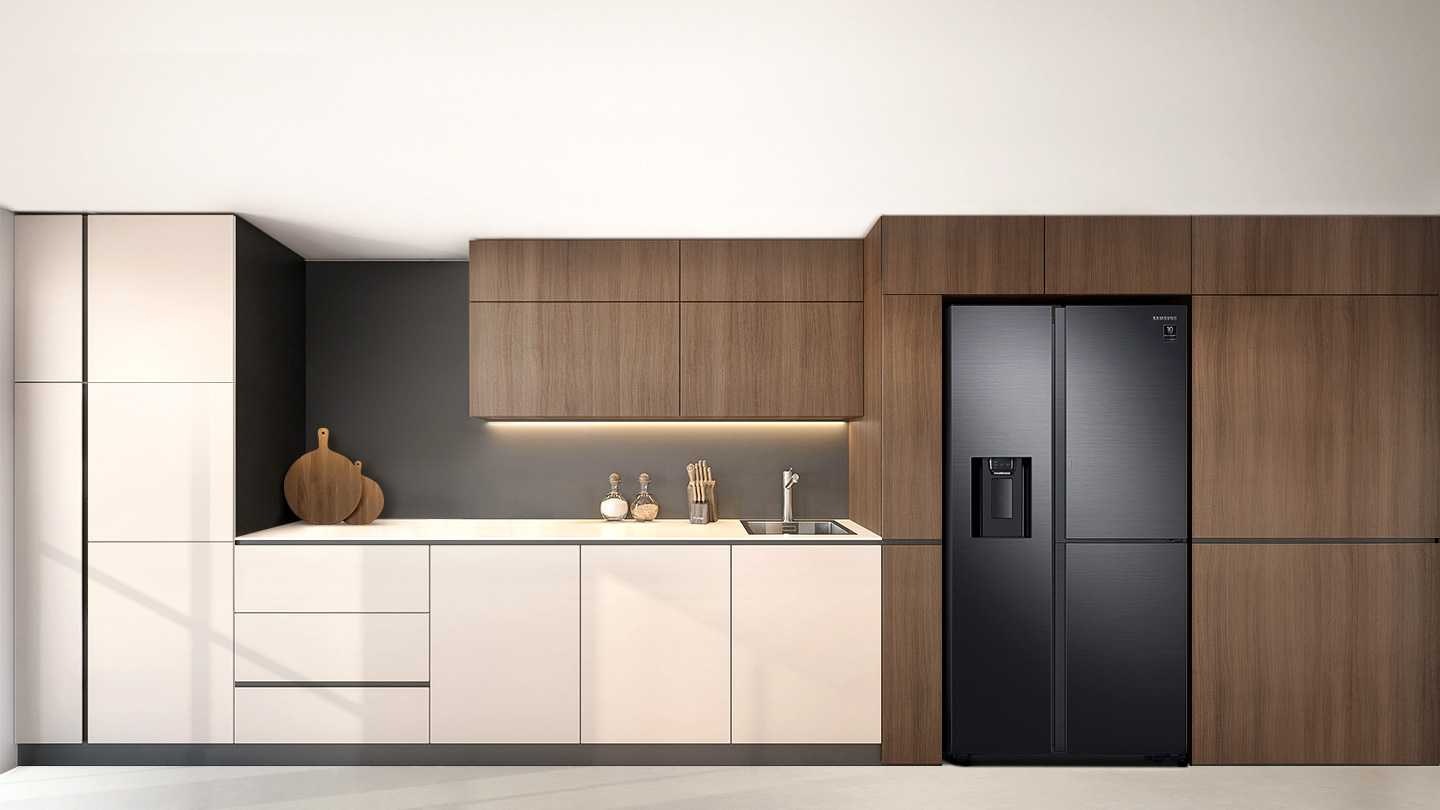 A 2-door fridge with a water dispenser is built into a stylish white and wood paneled kitchen.