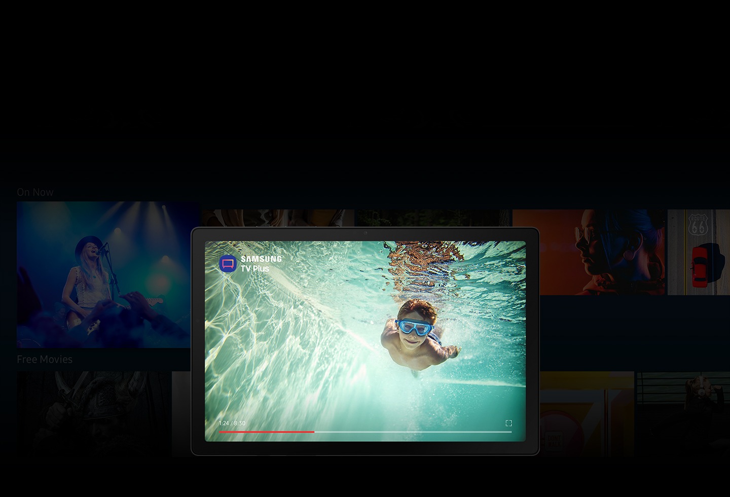 L'application Samsung TV Plus est ouverte sur la Galaxy Tab A8. Avec de nombreuses images floues d'émissions de télévision et de films en arrière-plan, l'écran affiche un garçon nageant sous l'eau avec l'icône de l'application et le logo de Samsung TV Plus.