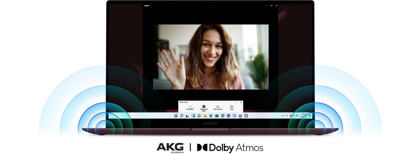 Un Galaxy Book2 Pro 360 est vu de face. Au centre de l'écran, une femme agite la main pendant un appel vidéo. Un son puissant sort des haut-parleurs situés dans les coins inférieurs du PC. Sous le PC se trouvent deux logos pour AKG® by Harman et Dolby Atmos.