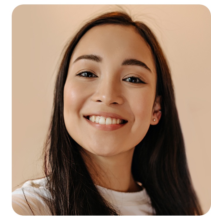 Une femme se photographie en souriant avec la caméra frontale de son téléphone.