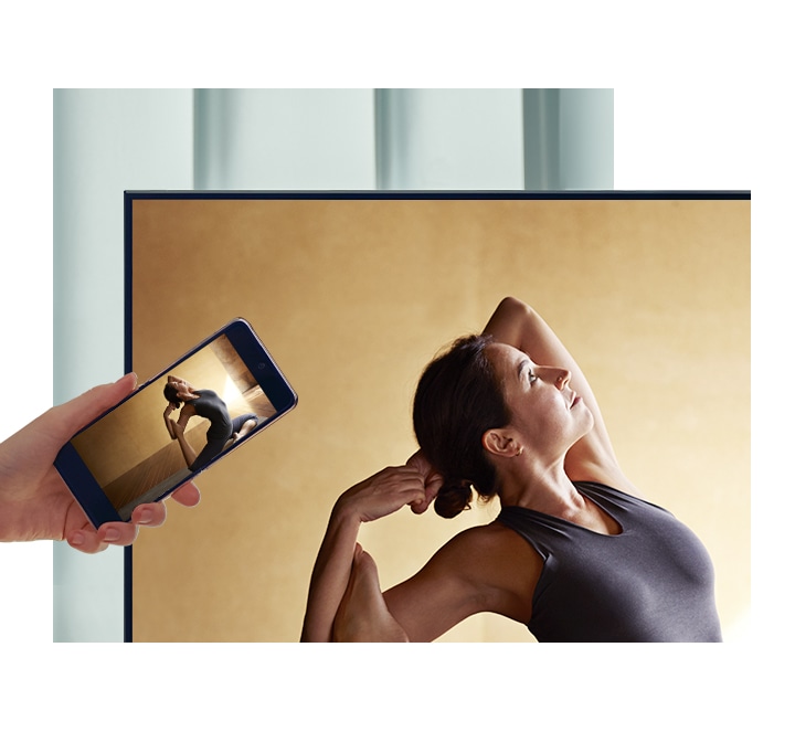 A user taps their smartphone against their QLED TV to mirror their ballerina contents to a bigger screen for more comfort.