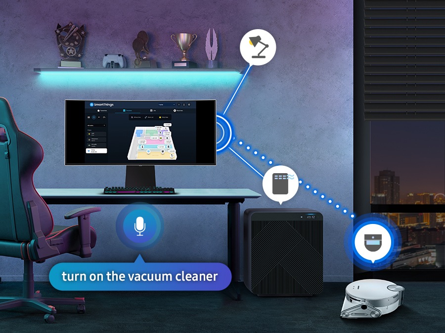 There is a monitor in a room with a vacuum cleaner, air purifier, and blind. All the devices are connected with the monitor with SmartThings, and the vacuum cleaner is activated by commanding at the SmartThings hub on the monitor in a voice saying 'turn on the vacuum cleaner'.