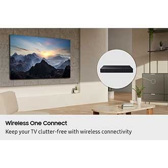 In a living room, a TV is installed cleanly on the wall with no wires. A Wireless One Connect box is hidden inside a cabinet.