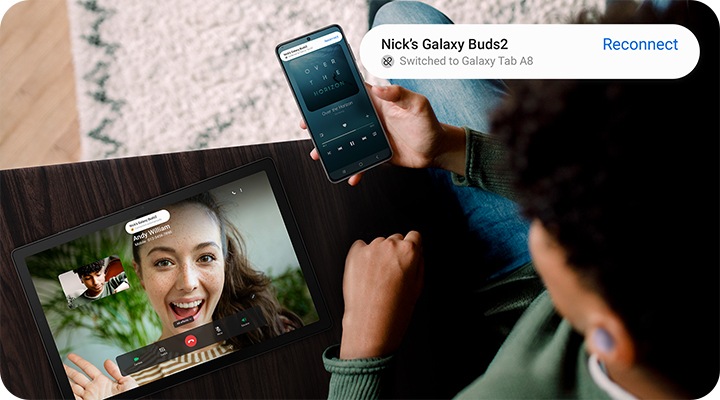 A man holding a Galaxy smartphone is enjoying a video call on Galaxy Tab A8. Notification indicates the Galaxy Buds he's wearing have automatically switched over to his tablet.