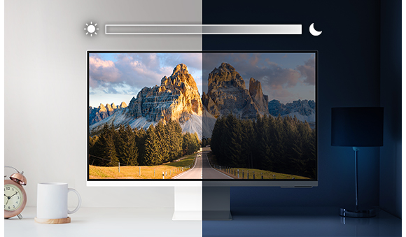A monitor sits on top of a desk and is split into left and right sides. The left side is brightly lit while the right side is very dark. Above the screen is a slider icon with a sun on the left and a moon on the right.