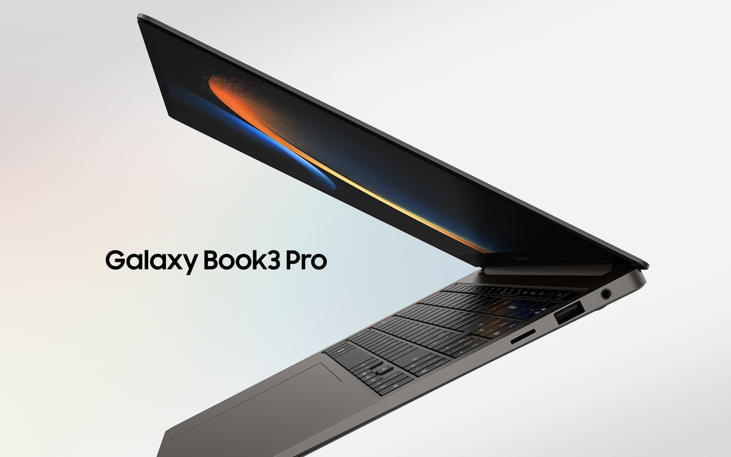 Графитовый Galaxy Book3 Pro наполовину открыт, обращен влево, а на экране черные обои.