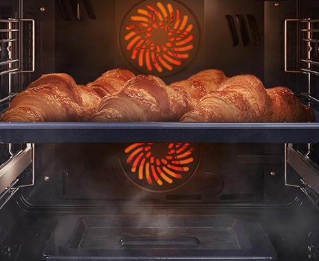 Shows a close-up of croissants being baked in the oven, but being kept moist with steam using the Natural Steam option.