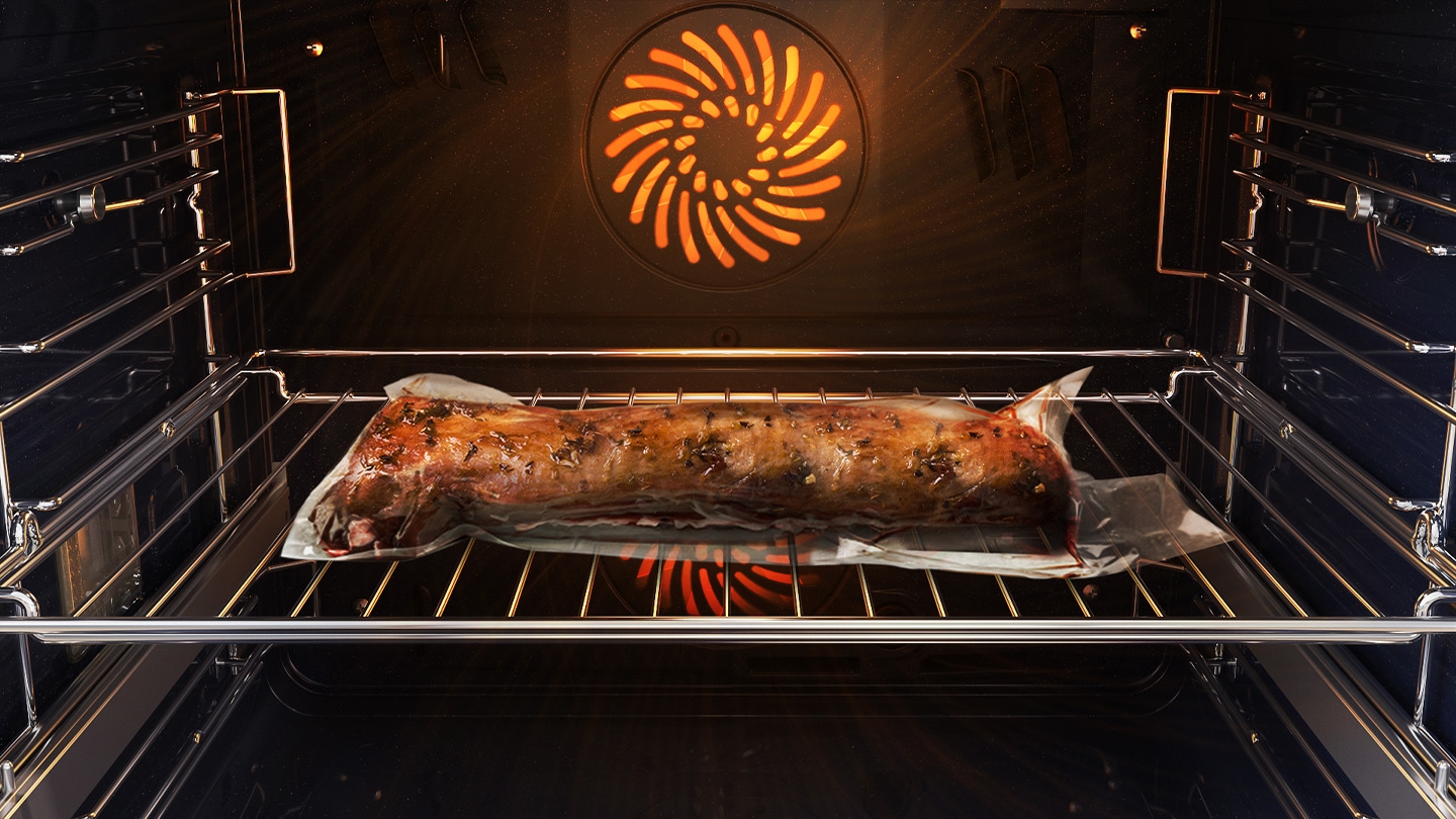 Prikazuje kos mesa v pečici, ki je tesno zaprt v plastični vrečki in na kovinskem pladnju, pečen s sistemom Air Sous Vide.