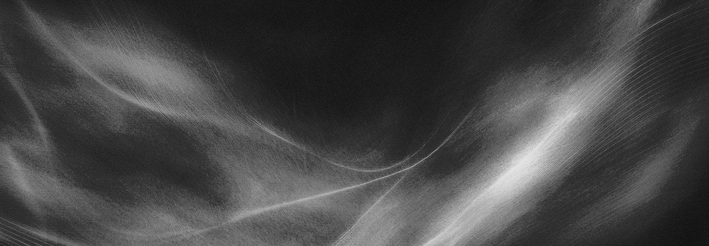 A wide abstract black-and-gray background with soft, smoky wave textures and subtle diagonal light streaks crossing near the center.