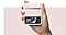 Egy kéz egy Galaxy Z Flip 4-et tart rózsaszín Kihajtható bőrtokban, elől mutatva a háttérképet.