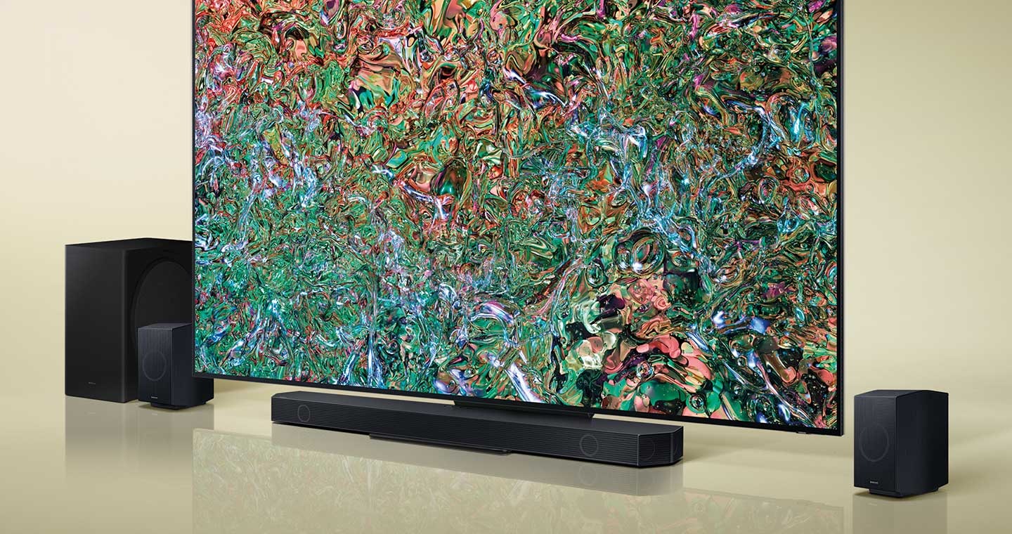 A big-screen TV is surrounded by various sound devices, including a Soundbar, a subwoofer and two rear speakers.