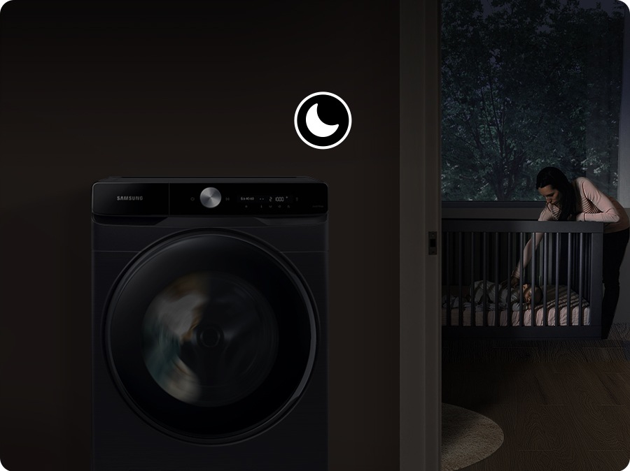 While the washer runs silently, the mother puts the baby to sleep at night.