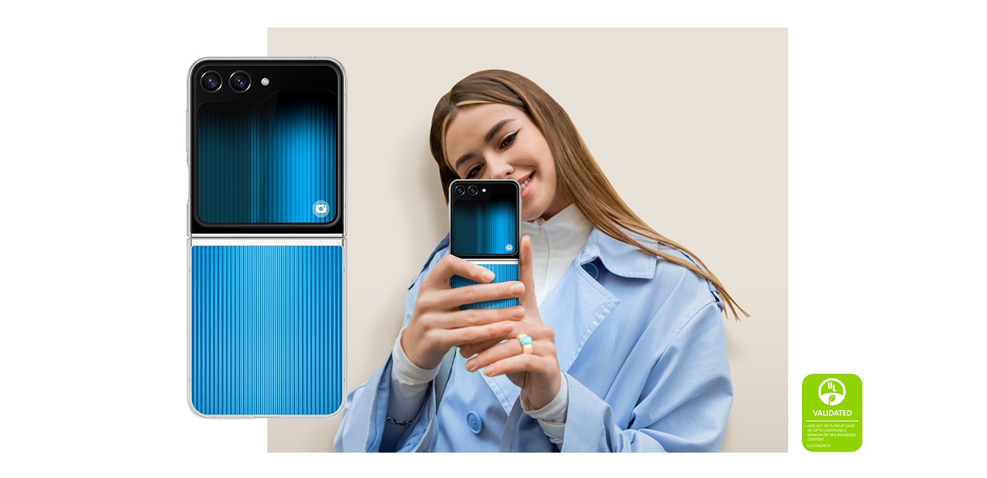 Tampilan belakang Galaxy Z Flip5 yang terbuka dan mengenakan Flipsuit Case yang aktif  dengan kartu interaktif ditampilkan. Seorang wanita tersenyum saat berpose untuk mirror selfie menggunakan perangkat. Teks tersebut memuat tulisan yang terbaca sebagai berikut,  TOMBOL SAMPING FLIPSUIT CASE (EF-ZF731) MENGANDUNG MINIMUM 34% KANDUNGAN BERBASIS NABATI. UL.COM/ECV